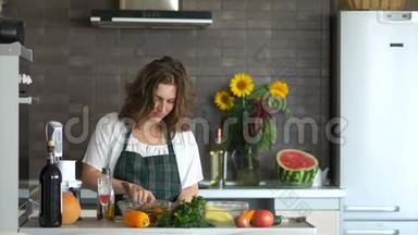 快乐的年轻女人在厨房里用刀跳舞。 准备沙拉，<strong>好</strong>心情。 <strong>母亲节</strong>